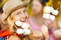 Portrait of girl holding sticks with marshmallow