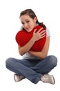 Portrait of a girl hugging a big red plush heart Royalty Free Stock Photo