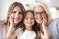 Portrait of girl hugging mom and grandmother making family pictu Royalty Free Stock Photo