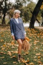 Portrait of a Girl in a jacket and birette with an autumn bouquet in an autumn park