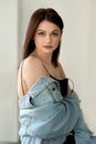 Portrait of girl in jeans jacket sitting on table in interior Royalty Free Stock Photo