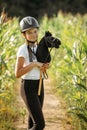 Portrait of a girl - a jockey, who holds a horse - a toy in her hands Royalty Free Stock Photo