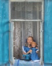 Portrait of girl kid tailor sew making doll& x27;s clothes on a children& x27;s sewing machine in the window of an old Royalty Free Stock Photo