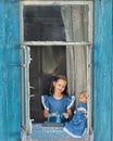 Portrait of girl kid tailor sew making doll& x27;s clothes on a children& x27;s sewing machine in the window of an old Royalty Free Stock Photo