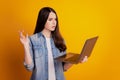 Portrait of girl with laptop confused serious problem look screen pc on yellow background