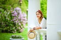 Portrait of a girl in a lilac blooming garden in spring in a white gazebo looking at the camera Royalty Free Stock Photo