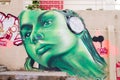 Portrait of girl listening music in green graffiti Royalty Free Stock Photo