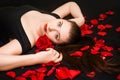 Portrait of a girl lying on a black background and rose petals. Royalty Free Stock Photo