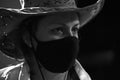 Portrait of a girl in a medical mask and a cowboy hat. Royalty Free Stock Photo