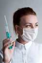 Portrait of a girl in a medical mask. Holding a syringe in her hand. Close up Royalty Free Stock Photo