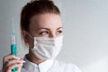 Portrait of a girl in a medical mask. Holding a syringe in her hand. Close up Royalty Free Stock Photo