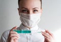 Portrait of a girl in a medical mask. Holding a syringe in her hand. Close up Royalty Free Stock Photo