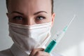 Portrait of a girl in a medical mask. Holding a syringe in her hand. Close up Royalty Free Stock Photo