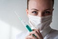 Portrait of a girl in a medical mask. Holding a syringe in her hand. Close up Royalty Free Stock Photo