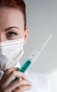 Portrait of a girl in a medical mask. Holding a syringe in her hand. Close up Royalty Free Stock Photo