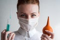 Portrait of a girl in a medical mask. Holding a syringe in her hand. Close up Royalty Free Stock Photo