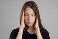 A young woman with a headache, holding her head, isolated on a white background. Portrait of a girl, medical theme, pain Royalty Free Stock Photo