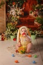 Portrait girl one year old in a bunny costume shooting in the studio in the background flowers wooden background dekor