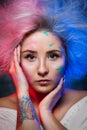 Portrait of the girl painter with color paint on face with tattoo on hand. Royalty Free Stock Photo