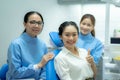 Portrait of girl patient smile, sitting on dental chair after doctor and assistant provide medical service. Young woman feel happy Royalty Free Stock Photo