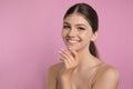 Portrait of pretty girl on pink background, space for text. Beautiful face with perfect smooth skin Royalty Free Stock Photo