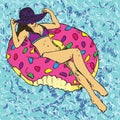 Portrait of girl in purple hat and bikini sunbathing on pink donut inflatable ring, blue clean water waves background