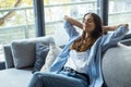 Portrait of a girl relaxing on a sofa after work at home sitting on a sofa in the living room at home. One young woman stretching Royalty Free Stock Photo