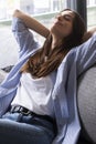 Portrait of a girl relaxing on a sofa after work at home sitting on a sofa in the living room at home. One young woman stretching Royalty Free Stock Photo