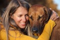 Portrait of a girl and a Rhodesian Ridgeback. The dog closed its eyes. Yellow background