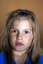 Portrait of a girl with ruined teeth and a face smeared with chocolate. Unhealthy diet, the harm of sugar for children.