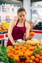 Portrait girl salesperson in a store checking the tangerines