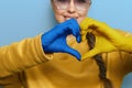 Portrait of girl showing heart shape Ukrainian yellow and blue flag on hands forming a heart. Ukraine support.