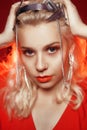 Portrait of a girl in a silver crown in the rays of red light. A woman in the image of a fashionable princess, queen. Chains on