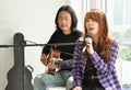 A girl singing a song with teacher who playing guitar in teaching room in the urban Royalty Free Stock Photo