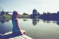 Portrait of a girl sitting on a bridge near the water