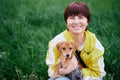 Portrait of a girl sitting with dachshund puppy with grass on background