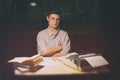 Portrait of a girl sitting at a table with a typewriter and books, think about the idea at night