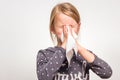 A girl is sneezing into a white handkerchief. Royalty Free Stock Photo