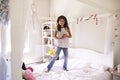 Portrait Of Girl Standing On Bed Listening To Music On Phone Royalty Free Stock Photo