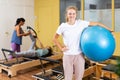 Portrait of girl standing with fitness ball during pilates training at gym Royalty Free Stock Photo