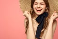 Portrait of a girl in a straw hat on a pink background emotions close-up beautiful face model pigtails