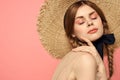 Portrait of a girl in a straw hat on a pink background emotions close-up beautiful face model pigtails