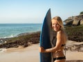 Portrait of surfer girl with surfboard at the beach. Young sexy woman wearing black bikini. Surfing lifestyle. Tegal Wangi beach, Royalty Free Stock Photo