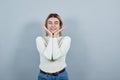 Portrait of girl teenager keeping hands near face isolated on gray wall