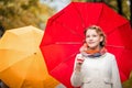 Portrait of a girl walking under bright red umbrella in the autumn city Royalty Free Stock Photo