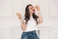 Portrait of a girl in a white T-shirt with curly dark hair and red lips. Girl playing with waffle cups for ice cream.