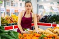 Portrait girl salesperson in a store checking the tangerines