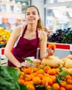 Portrait girl salesperson in a store checking the tangerines