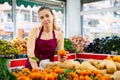 Portrait girl salesperson in a store checking the tangerines