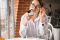 Portrait of a girl working in a cafe holds a smartphone in her hand speaks activates the virtual digital voice assistant